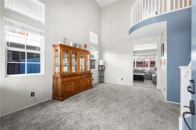 interior space featuring a high ceiling and baseboards