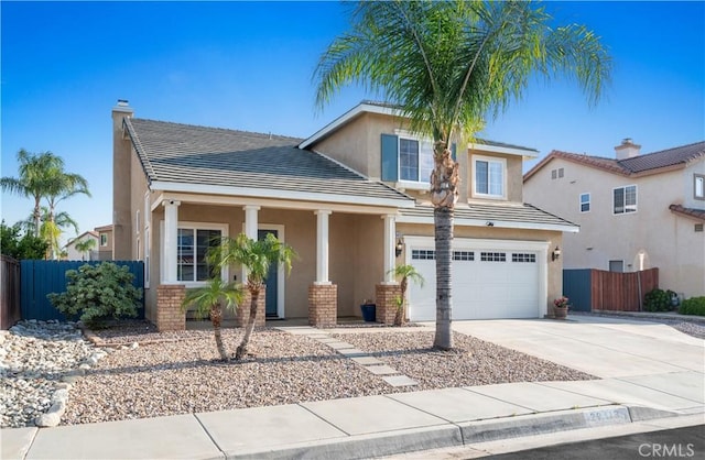 view of front of property with fence, stucco siding, driveway, and a garage