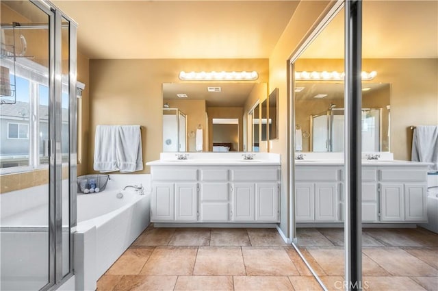 full bathroom with a sink, a stall shower, and double vanity
