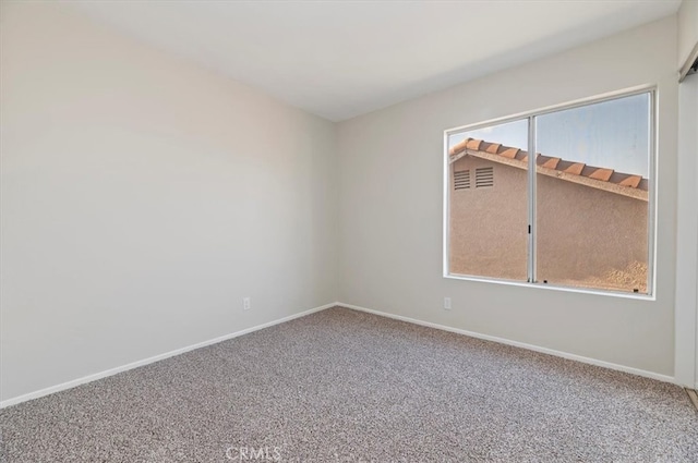carpeted empty room with baseboards