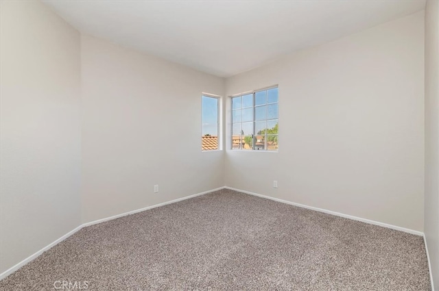 carpeted empty room with baseboards