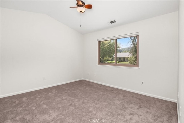 unfurnished room with visible vents, baseboards, carpet floors, and vaulted ceiling