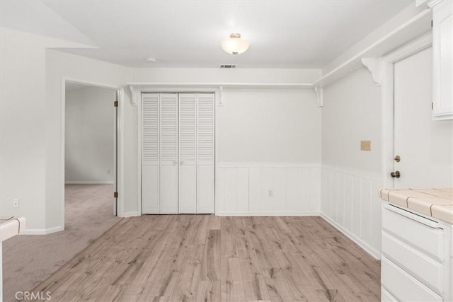 interior space with light wood-style floors and visible vents