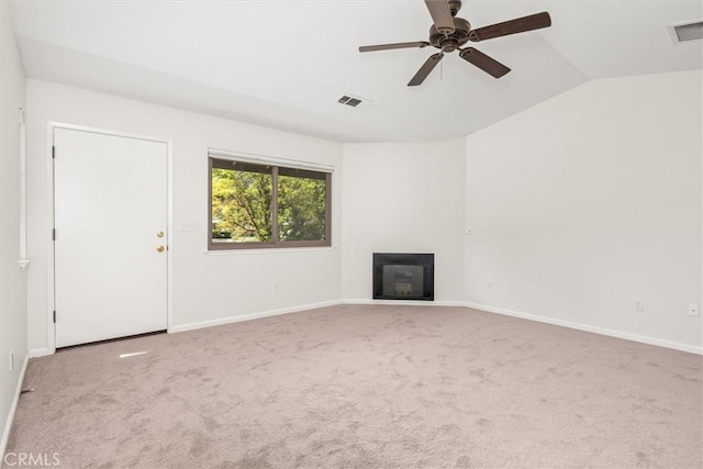 unfurnished living room featuring ceiling fan, a fireplace, carpet, lofted ceiling, and visible vents