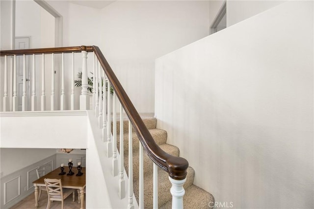 stairway featuring a decorative wall