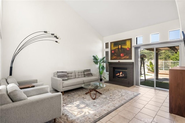living area with a brick fireplace, high vaulted ceiling, and tile patterned floors