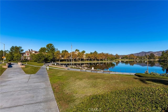 view of property's community with a yard and a water and mountain view