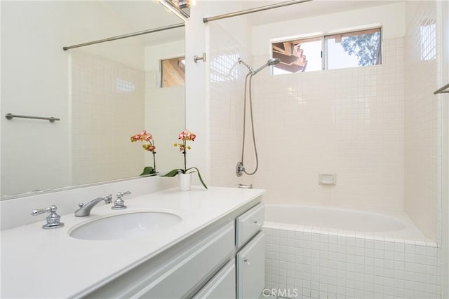 full bathroom with tiled shower / bath combo and vanity