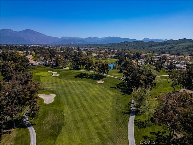 drone / aerial view with a water and mountain view and golf course view