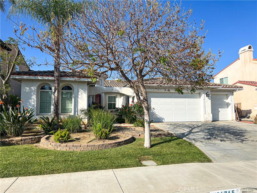 mediterranean / spanish-style home with concrete driveway, an attached garage, a tile roof, and stucco siding
