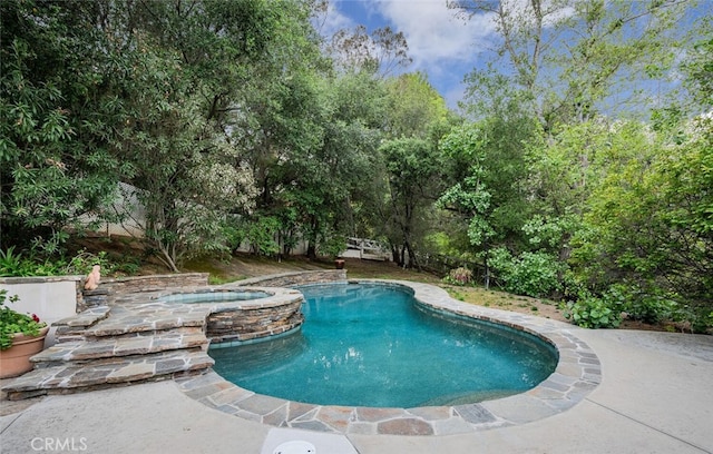 view of pool with a pool with connected hot tub