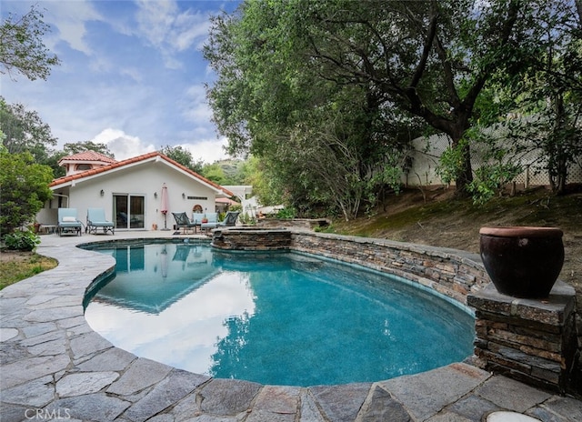 view of swimming pool featuring a pool with connected hot tub and a patio area