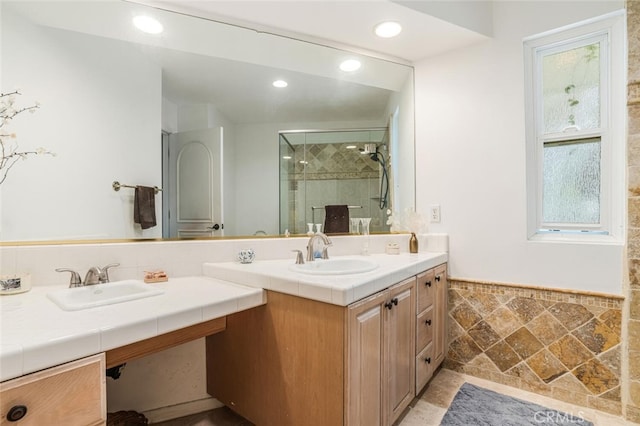 bathroom featuring vanity, a wainscoted wall, recessed lighting, tile walls, and a stall shower