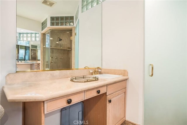bathroom with vanity, a shower stall, and visible vents