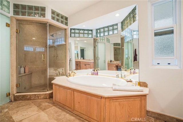 bathroom with vanity, a garden tub, and a stall shower