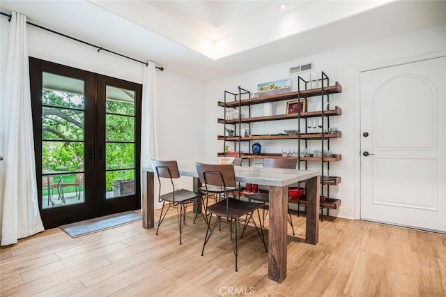 dining area with french doors, light wood-style flooring, and visible vents