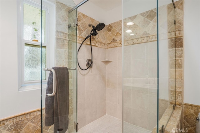 bathroom with a shower stall and a healthy amount of sunlight