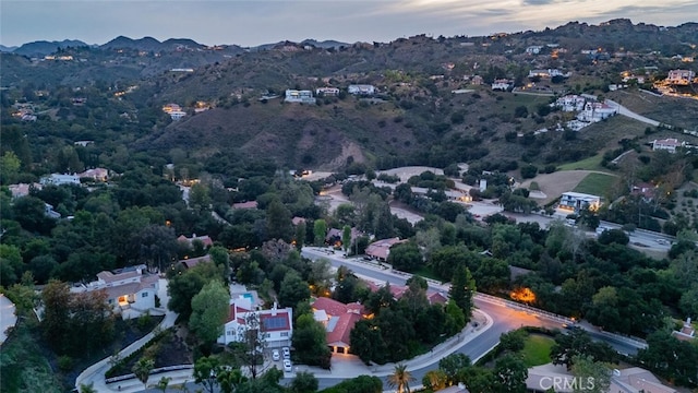 aerial view at dusk featuring a mountain view