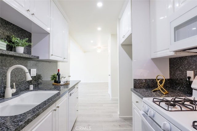 kitchen with a sink, decorative backsplash, white appliances, and white cabinets