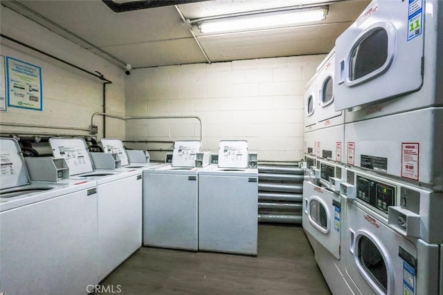 shared laundry area with separate washer and dryer, stacked washer / dryer, and concrete block wall