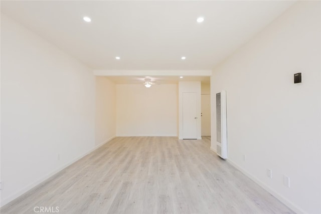 unfurnished room featuring ceiling fan, light wood-type flooring, baseboards, recessed lighting, and a heating unit
