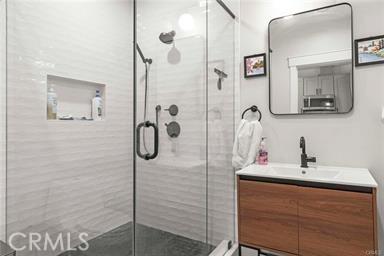 full bathroom with a shower stall and vanity