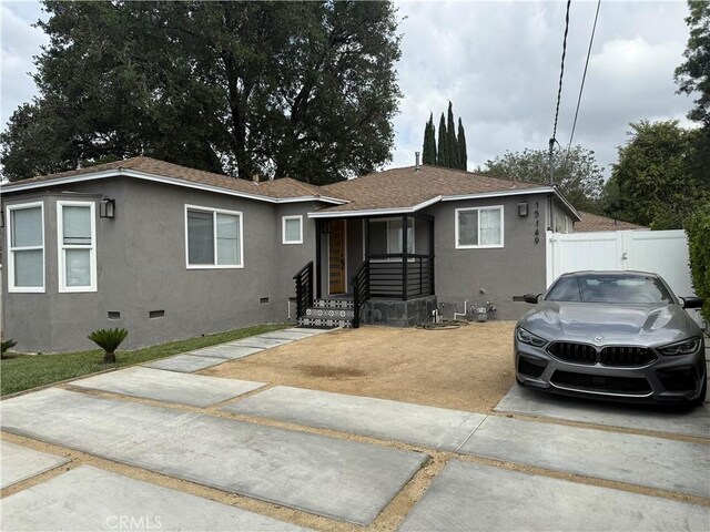 ranch-style house with fence, stucco siding, and crawl space