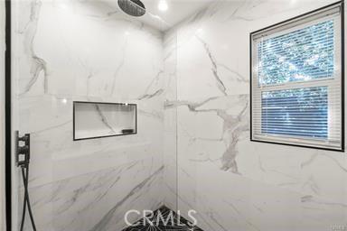 full bath with a marble finish shower