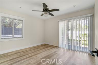 empty room featuring baseboards, a ceiling fan, and wood finished floors