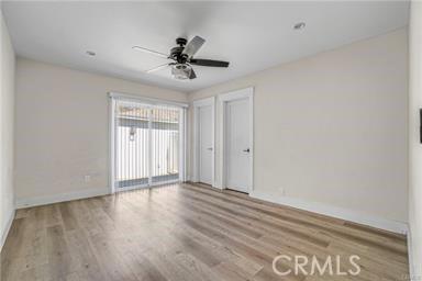 spare room featuring baseboards, ceiling fan, and wood finished floors