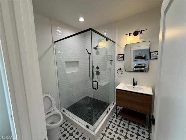 bathroom featuring tile patterned flooring, a stall shower, vanity, toilet, and recessed lighting