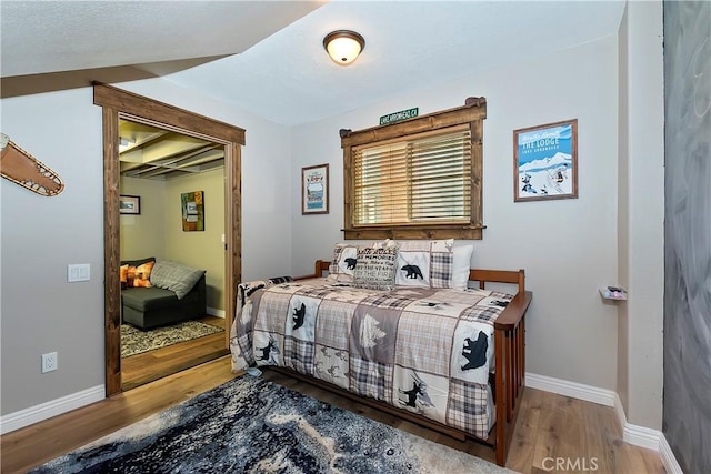 bedroom with baseboards and wood finished floors