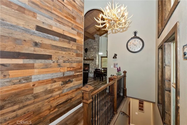 28844 Cedar Dr, Lake Arrowhead, CA 92352 - hallway featuring a chandelier, wooden walls, an upstairs landing, and wood finished floors