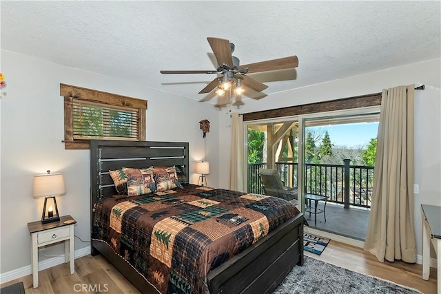 bedroom featuring light wood-type flooring, a textured ceiling, baseboards, and access to outside