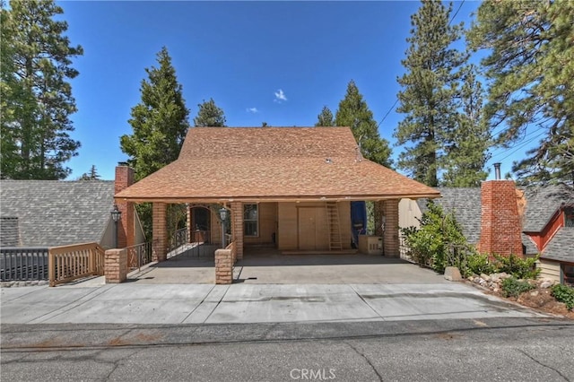 view of front of home with a shingled roof and concrete driveway