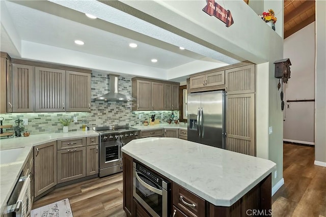 28844 Cedar Dr, Lake Arrowhead, CA 92352 - kitchen featuring appliances with stainless steel finishes, wall chimney exhaust hood, a tray ceiling, tasteful backsplash, and recessed lighting