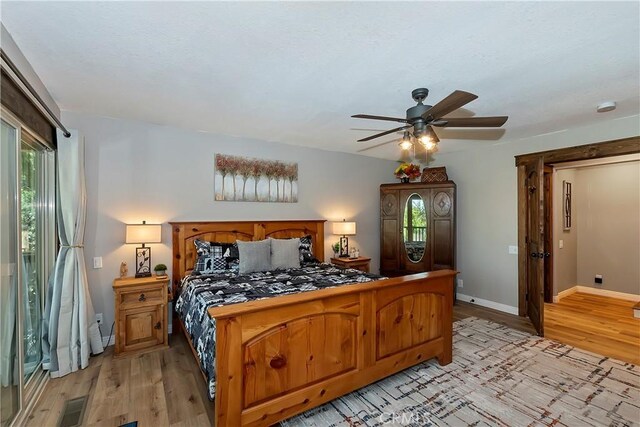 bedroom with a ceiling fan, baseboards, visible vents, and light wood finished floors