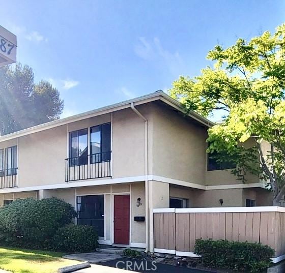 view of property featuring stucco siding and fence