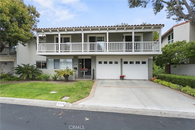 front facade featuring a balcony, a tile roof, and stucco siding