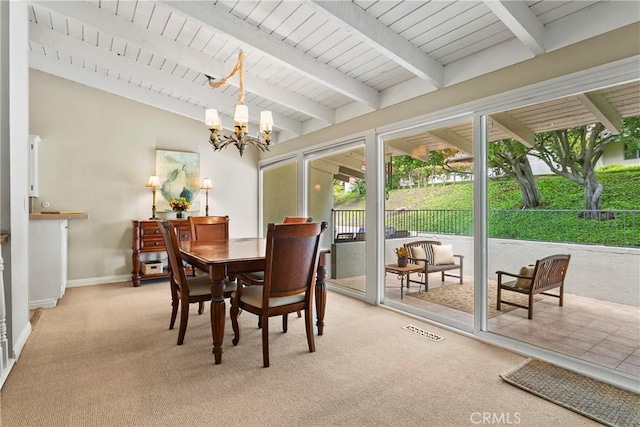 dining space featuring an inviting chandelier, visible vents, beamed ceiling, and light colored carpet