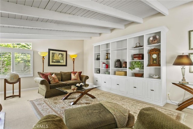 living area with baseboards, light carpet, and beam ceiling