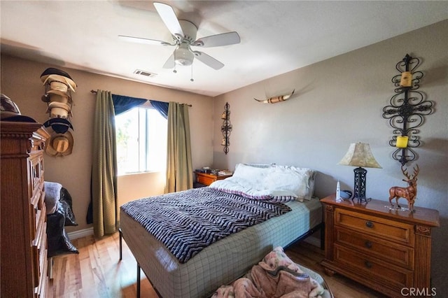 bedroom featuring visible vents, light wood-style floors, ceiling fan, and baseboards