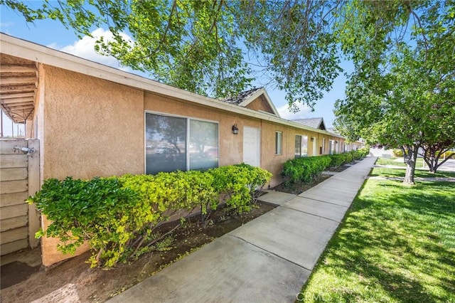view of home's exterior featuring a lawn and stucco siding