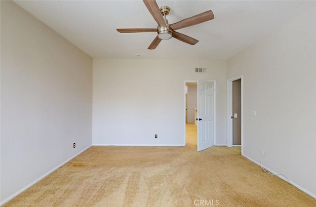 unfurnished room with visible vents, baseboards, ceiling fan, and light colored carpet