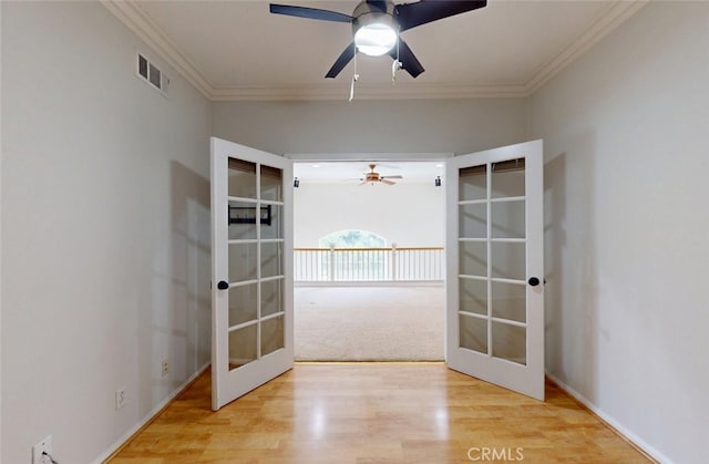 interior space with french doors, crown molding, ceiling fan, and visible vents