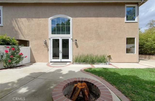 rear view of property with french doors, stucco siding, and a patio area
