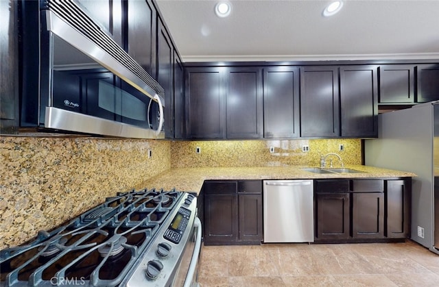 kitchen with a sink, decorative backsplash, light stone countertops, and stainless steel appliances
