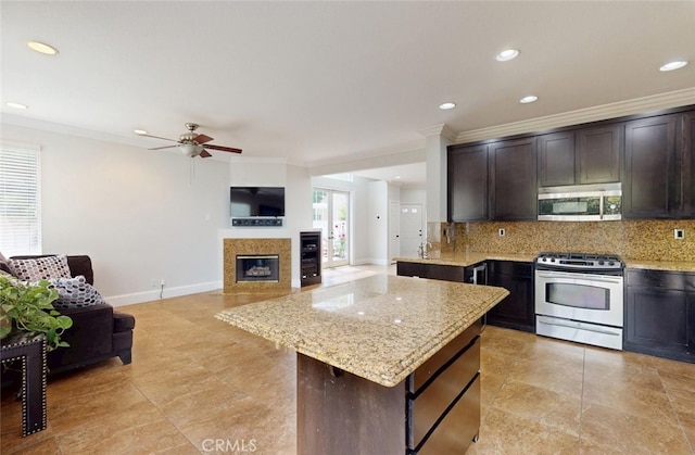 kitchen with crown molding, ceiling fan, stainless steel appliances, and tasteful backsplash