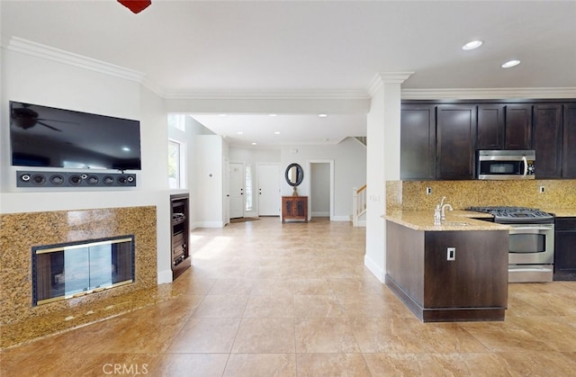 kitchen with dark brown cabinetry, backsplash, baseboards, ornamental molding, and stainless steel appliances