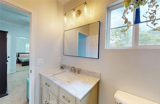 bathroom with crown molding, toilet, a wealth of natural light, and vanity